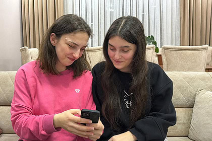 Gençler telefonla haberleri takip ediyor.