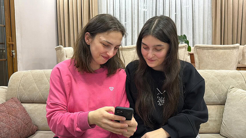 Gençler telefonla haberleri takip ediyor.