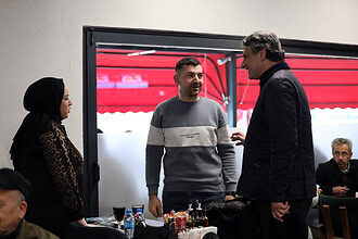 İnsanlar samimi şekilde sohbet ederken restoran içi ortam.