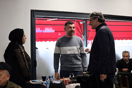 İnsanlar samimi şekilde sohbet ederken restoran içi ortam.