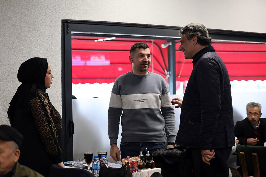 İnsanlar samimi şekilde sohbet ederken restoran içi ortam.