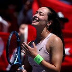 Tenisçi kadın, sevincini gösterirken, Türk bayrağı ve seyircilerle dolu atmosferde büyük sevgiyle karşılandı.