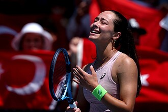 Tenisçi kadın, sevincini gösterirken, Türk bayrağı ve seyircilerle dolu atmosferde büyük sevgiyle karşılandı.