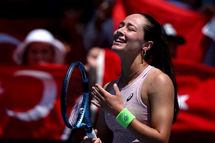 Tenisçi kadın, sevincini gösterirken, Türk bayrağı ve seyircilerle dolu atmosferde büyük sevgiyle karşılandı.