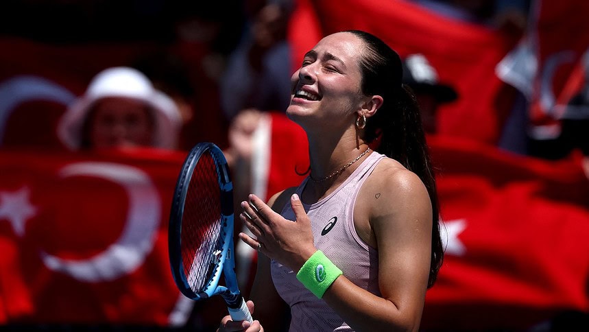 Tenisçi kadın, sevincini gösterirken, Türk bayrağı ve seyircilerle dolu atmosferde büyük sevgiyle karşılandı.