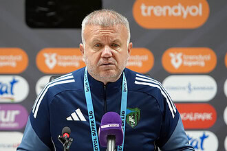 Futbol teknik direktörü press konferansında kameralar önünde konuşma yapıyor.
