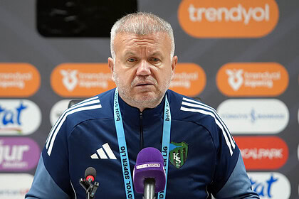 Futbol teknik direktörü press konferansında kameralar önünde konuşma yapıyor.