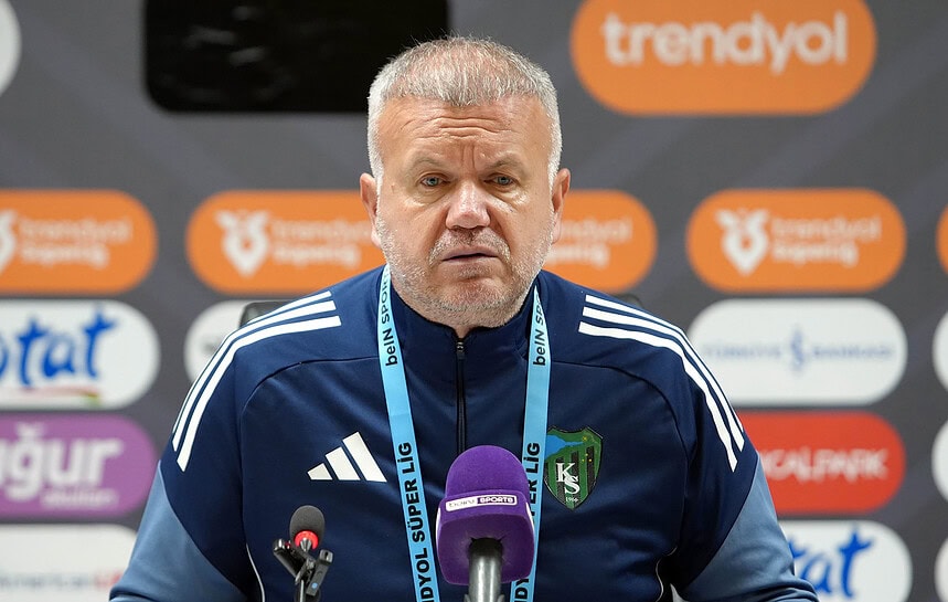 Futbol teknik direktörü press konferansında kameralar önünde konuşma yapıyor.