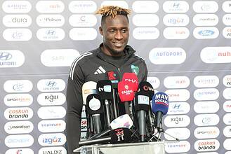 Daniel Agyei, basın toplantısında konuşurken, spor salonu arka planda.