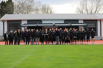 Kocaelispor futbolcuları ve genç dernek üyeleri birlikte fotoğraf çekimi yapıyor.