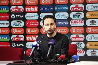Futbolcu, basın toplantısında konuşma yaparken mikrofonlara cevap veriyor.