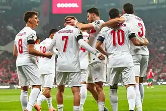Milli Takım oyuncuları maç öncesi takımla birlikte ısınırken.