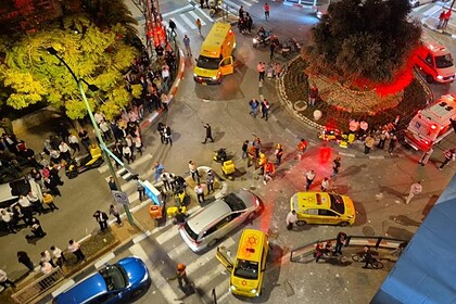İran'dan İsrail'e füze saldırısı sonucu 7 kişi yaralandı. Olay yerinde ambulanslar ve güvenlik güçle.