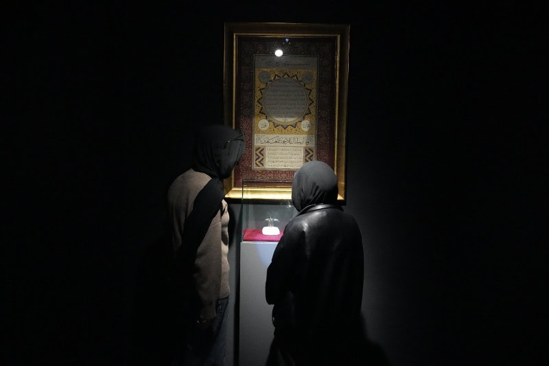 Emanetler sergisinde iki ziyaretçi, kutsal emanetleri inceliyor.