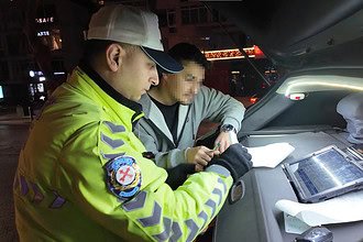 Yüksek görünümde trafik polisi, araç içinde ceza kesiyor.