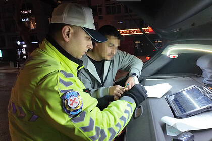 Yüksek görünümde trafik polisi, araç içinde ceza kesiyor.