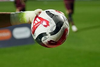 Kaleci elinde futbol topu, maçta önemli an.