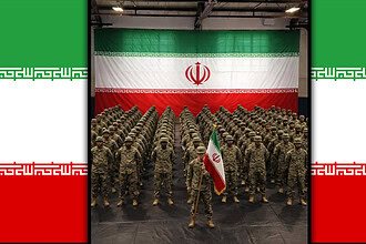 İran ordusu askerleri, büyük İran bayrağı önünde saf tutuyor.